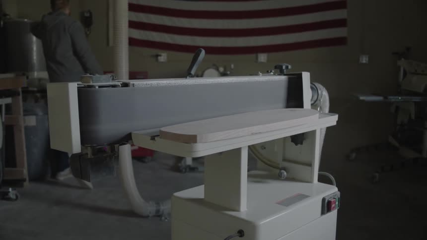 A man walks over to turn on a machine to begin work