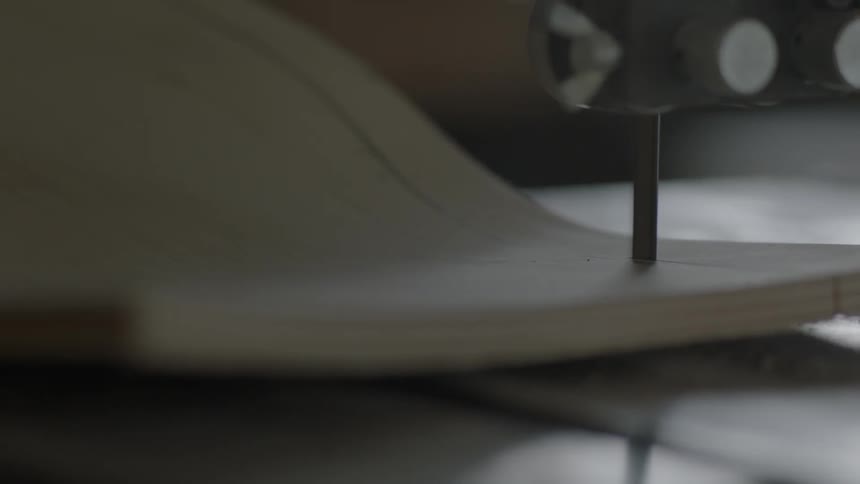 A wooden board being cut and shaped by a machine
