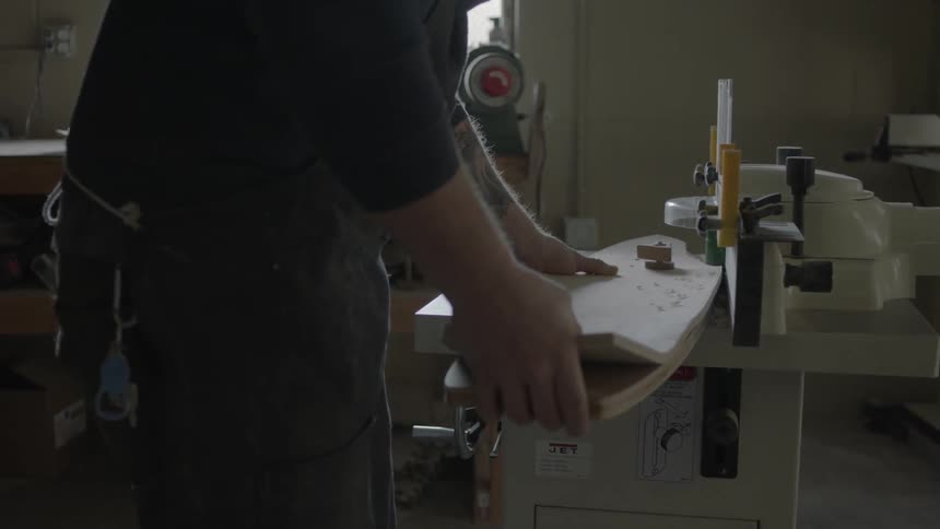 Man sanding a piece of wood with the help of a machine