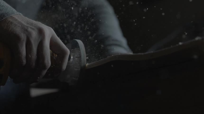 Person using a sander to smooth out a wooden board