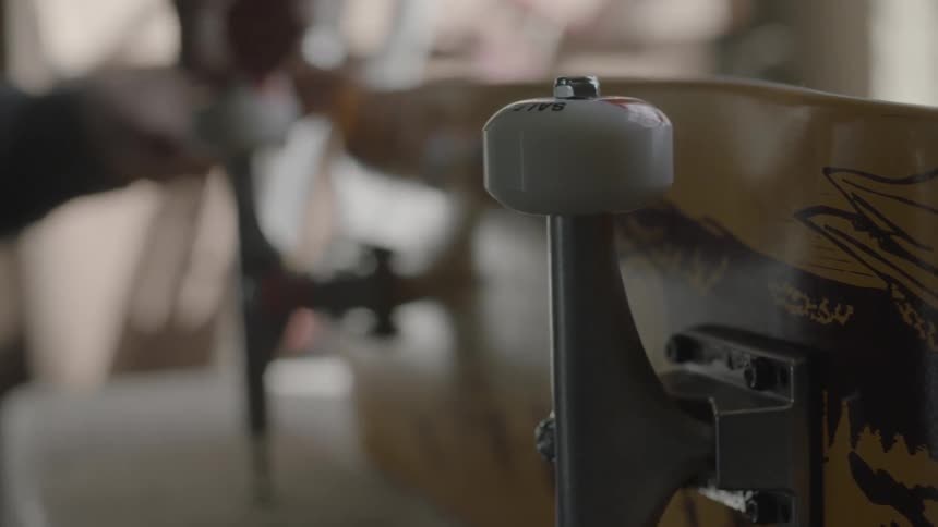 A man fastening wheels onto the trucks of a skateboard