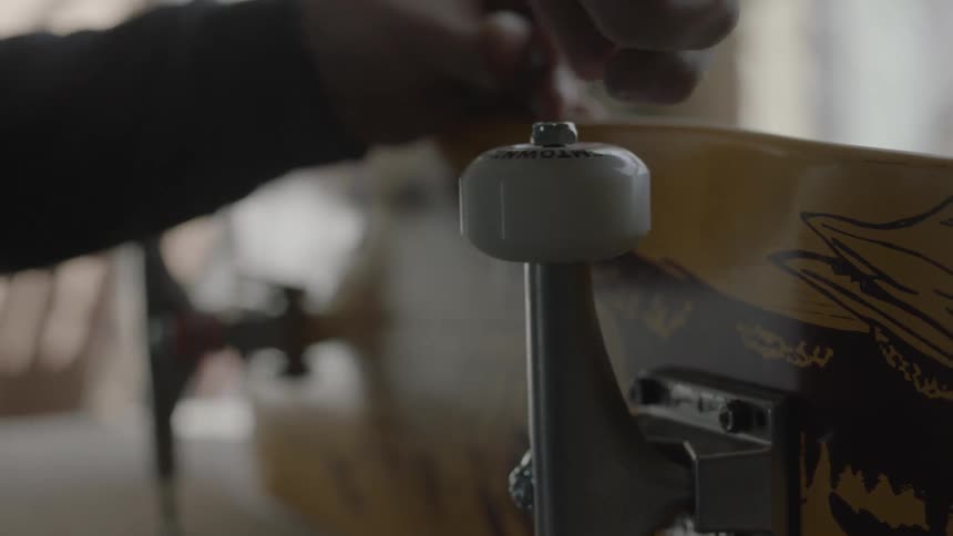 Man tightens a bolt on a skateboard wheel