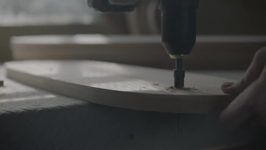 A man using a drill on a piece of wood