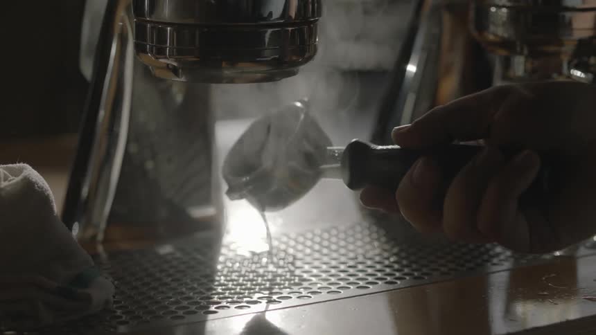 A person rinsing a piece of equipment in steaming water