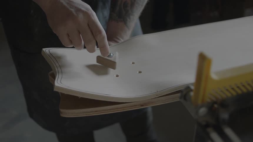 A person turning a screw and wooden triangle on a board