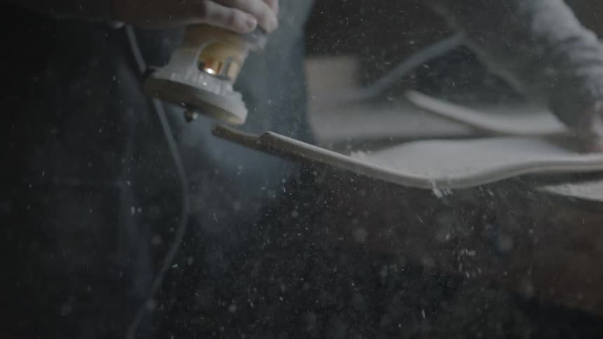 A man using an electric sander on wood