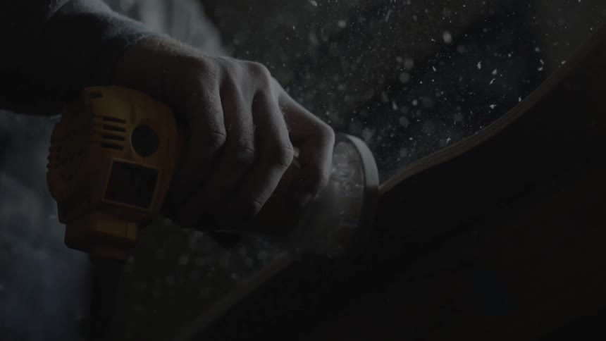 A man is sanding some wood