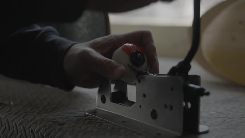 A person uses a device to press a roller skate wheel