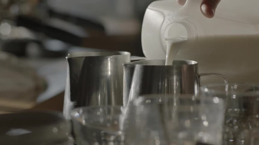 Milk is poured into a metal cup