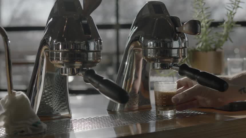 Person getting a hot beverage in a small glass