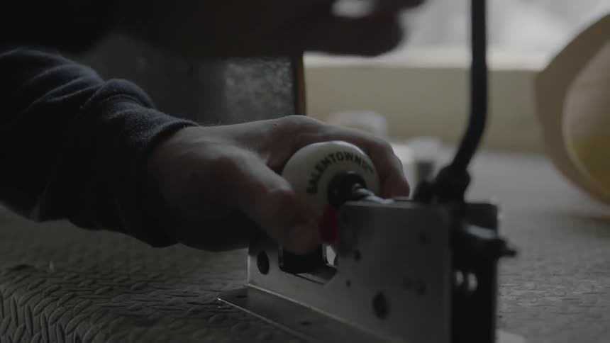A man puts a skateboard wheel into a piece of equipment