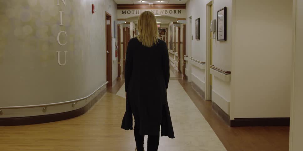 Woman walking down a newborn intensive care unit hallway
