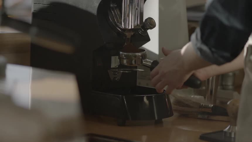 A worker uses a piece of equipment at a coffee shop