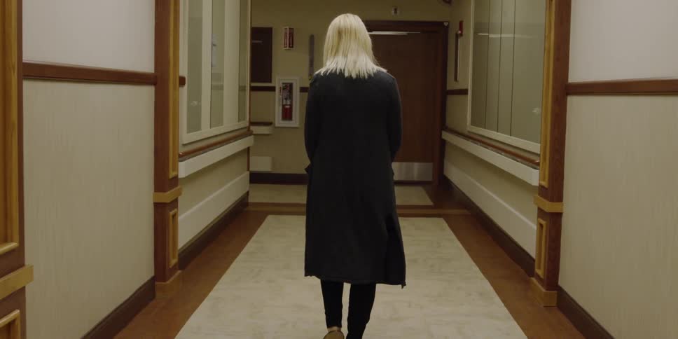 Woman walks down the hallway of a large building