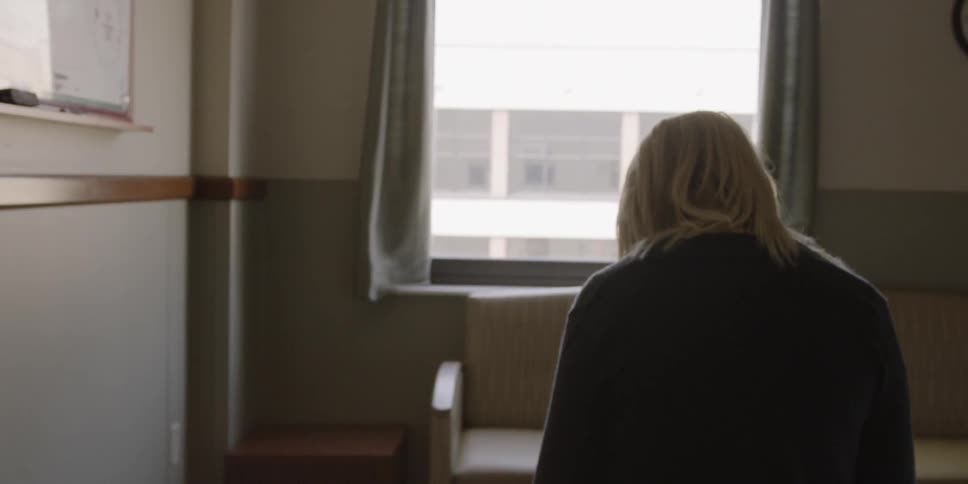 Woman sitting on a bed in an empty room