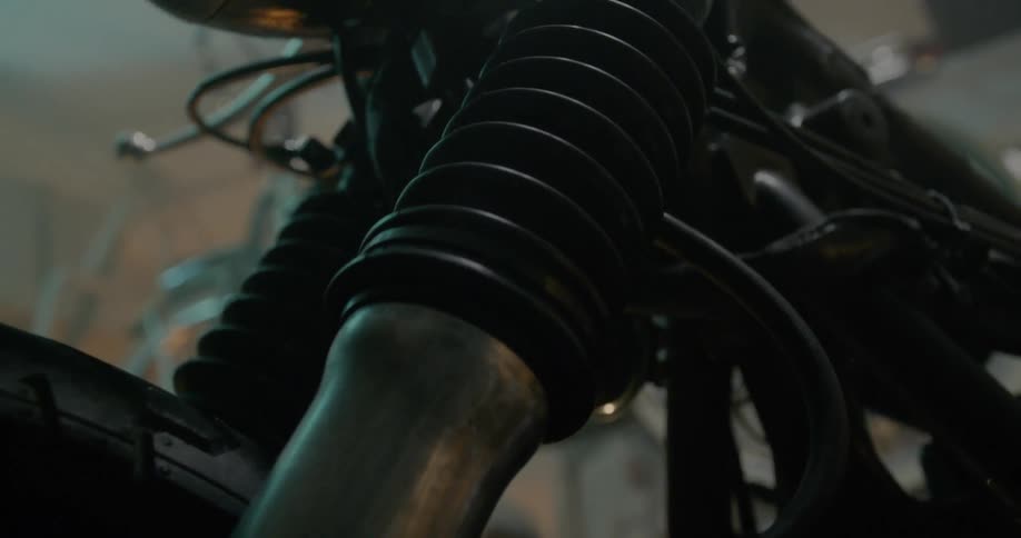 A motorcycle sits all alone in a dark garage