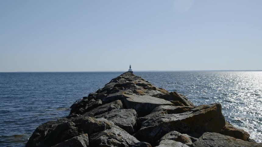 The tide flows up to and against the rocks