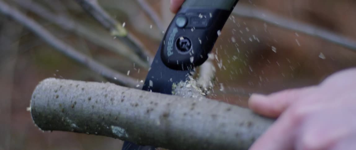 A small saw cutting through a tree branch