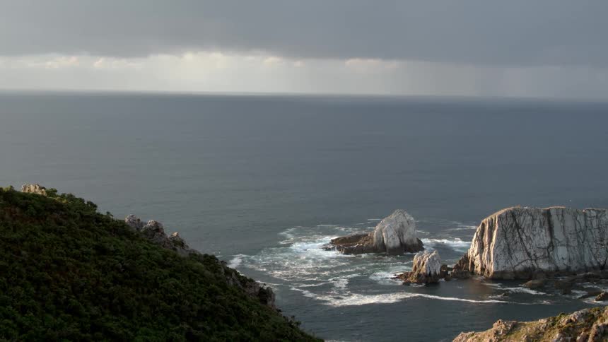 Grassy mountains next to a calm sea