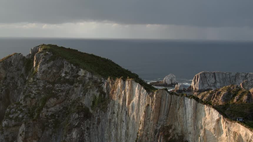 Slow pan over a mountain next to the sea