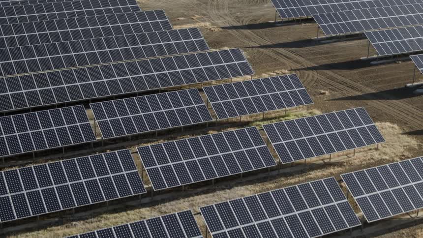 Row after row of solar panels cover the barren ground