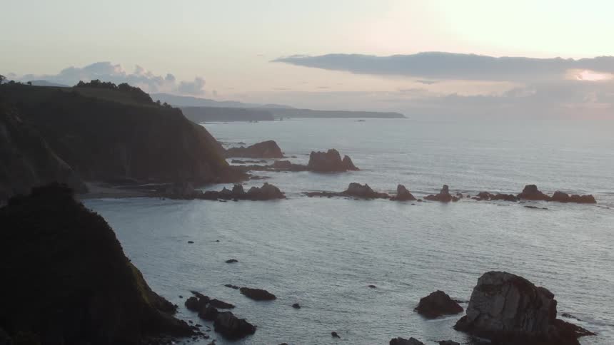 A calm sea moving around large rocks