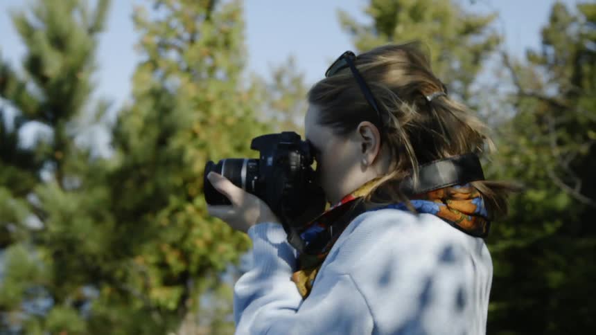 Woman taking a picture with her camera and taking a step back