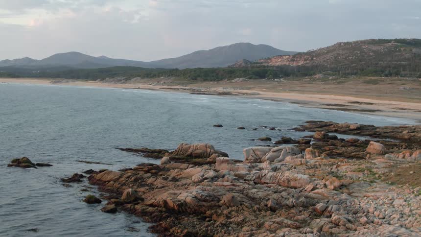 Pan over a rocky beach next to the sea