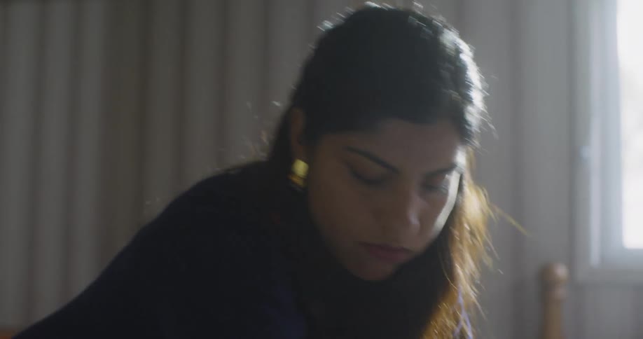 Woman laying a suitcase on her bed and opening it