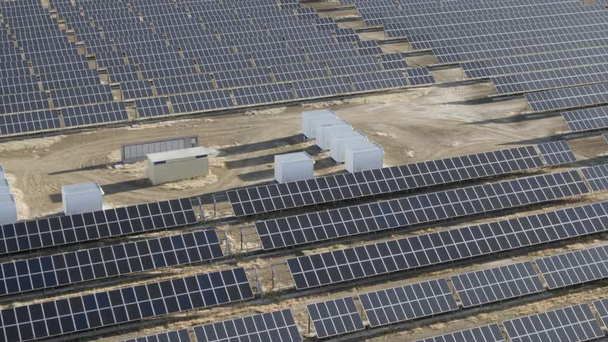A solar farm sits in the desert in the sunlight