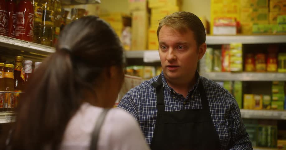 A grocery worker helps a customer