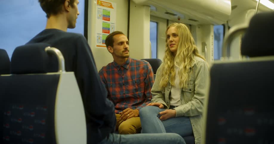Woman laughing and talking with two man in a train