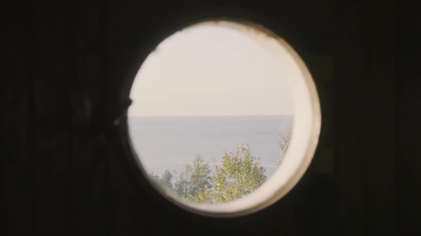 A view of water and trees through a peephole
