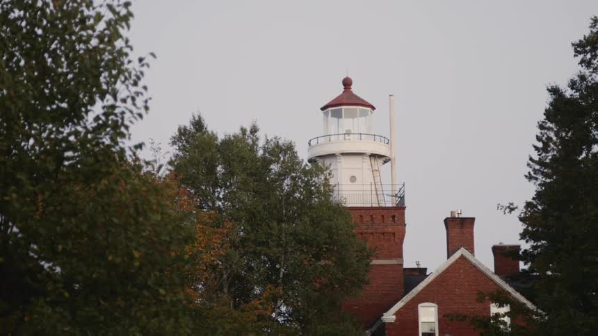 A flash of light comes from inside a lighthouse