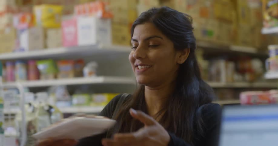 Woman checks out at grocery store and talks to clerk