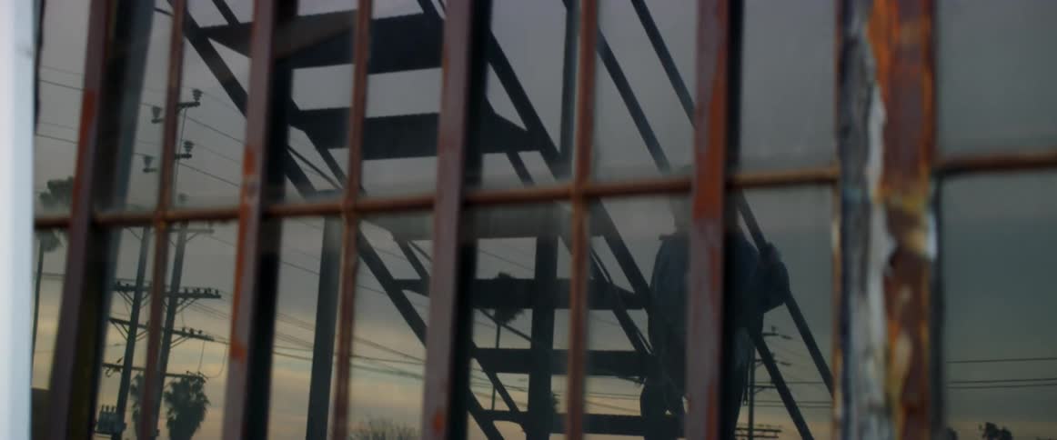 A young girl climbs a set of metal stairs at dusk