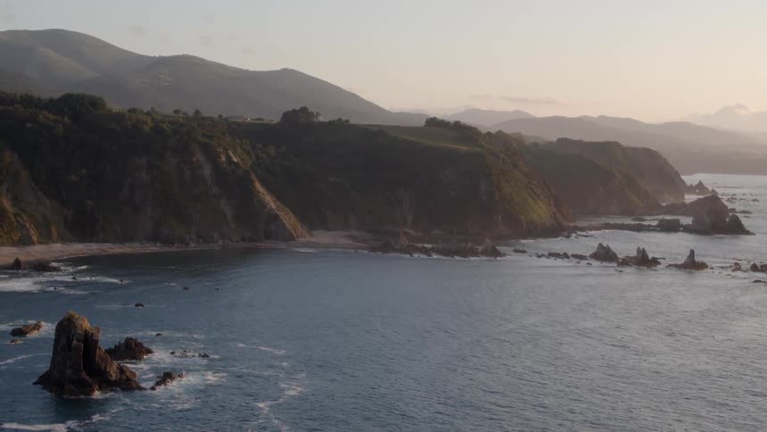 A calm sea with waves crashing on a mountain