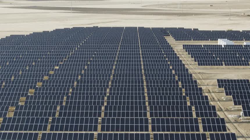 A huge solar farm sits in the desert in the sunlight