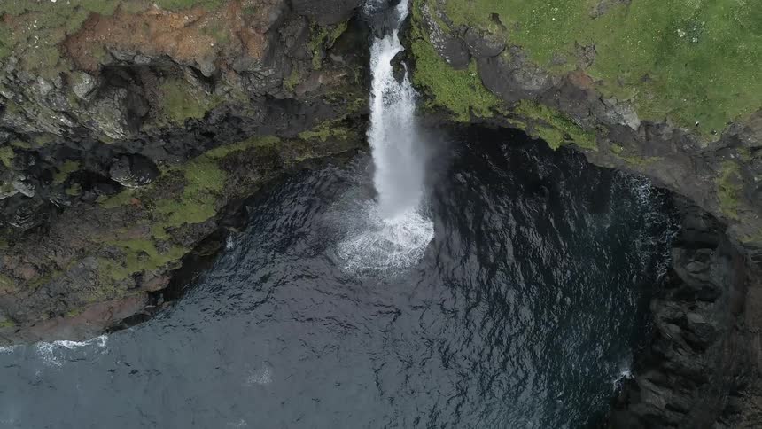 Water rushes down a cliff creating a waterfall