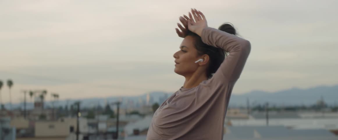 Woman stretches and moves her arms outside in the city