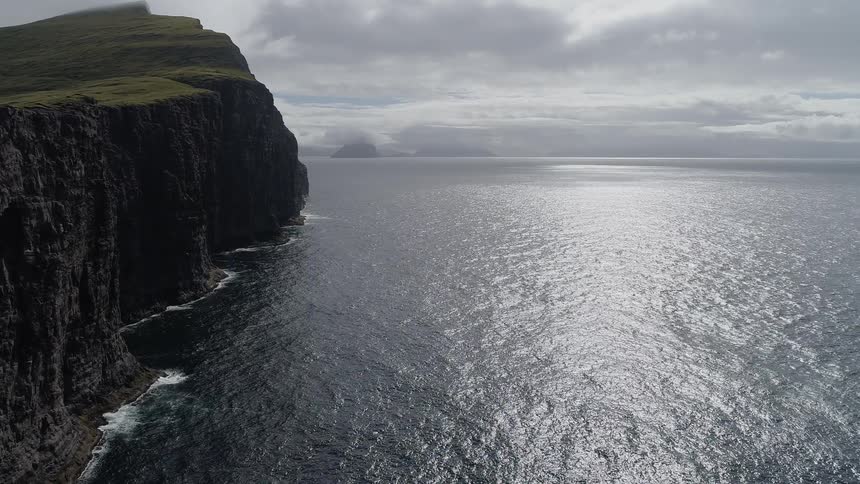 A large mountain cliff overlooking a calm sea