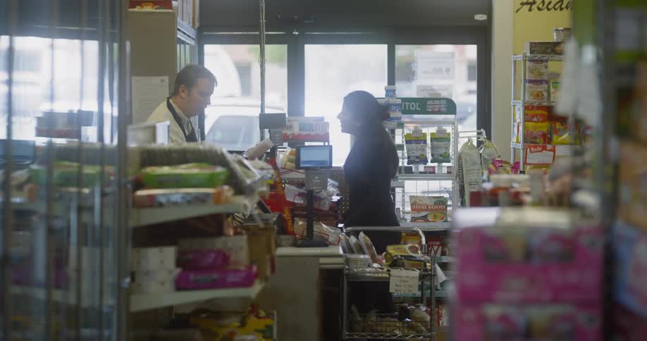 Woman at the grocery counter talking to the clerk