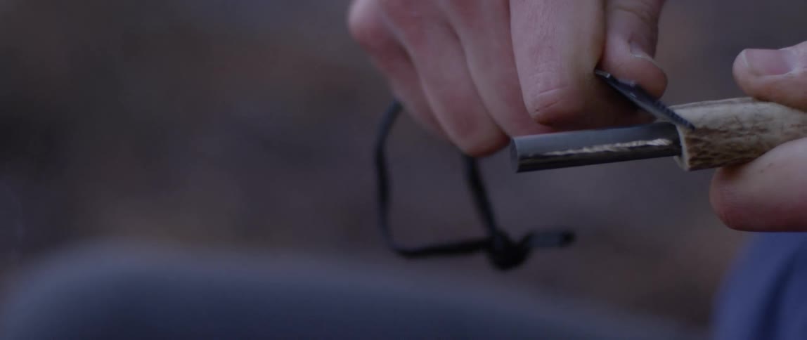 A man creates a spark with two pieces of metal