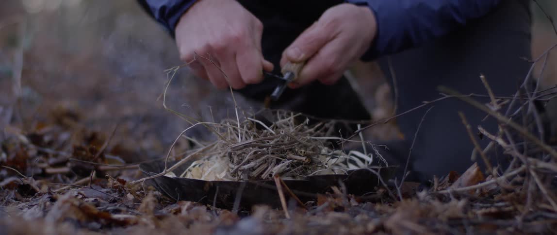 Man starting a small fire with flint and steel