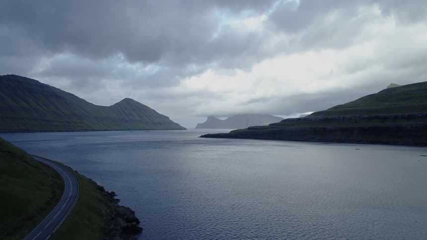 Calm water flows through a valley made by two mountains on each side of the river