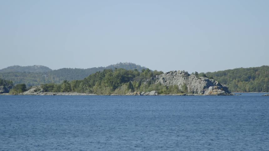 A rocky hill next to a flowing river