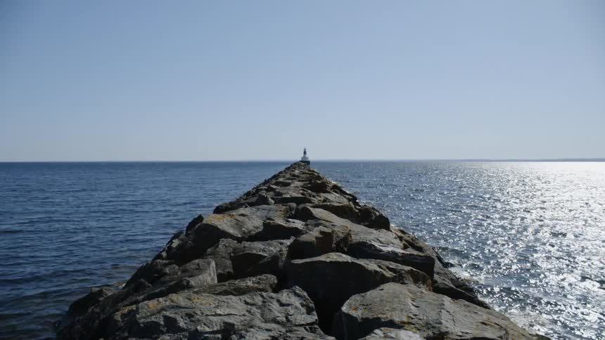 Someone standing on a rocky pier overlooking the sea
