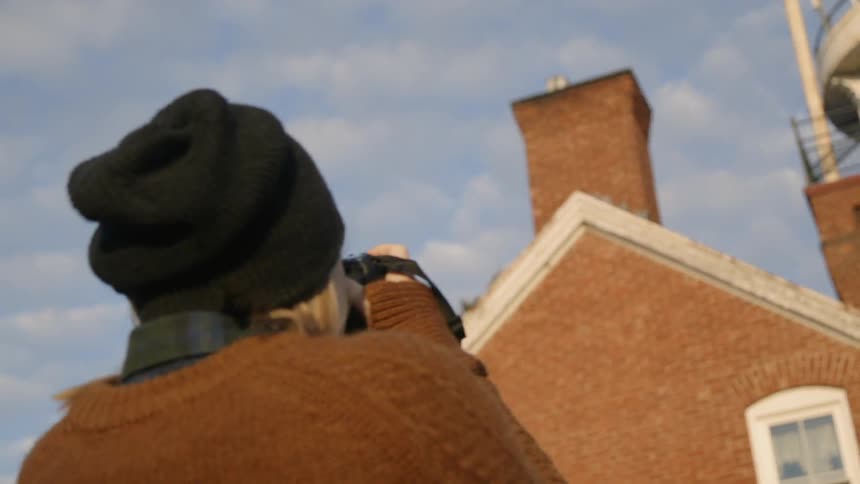 Woman taking a picture of a lighthouse
