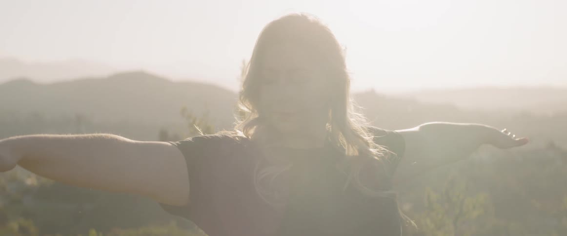 Woman doing yoga outdoors on a bright day