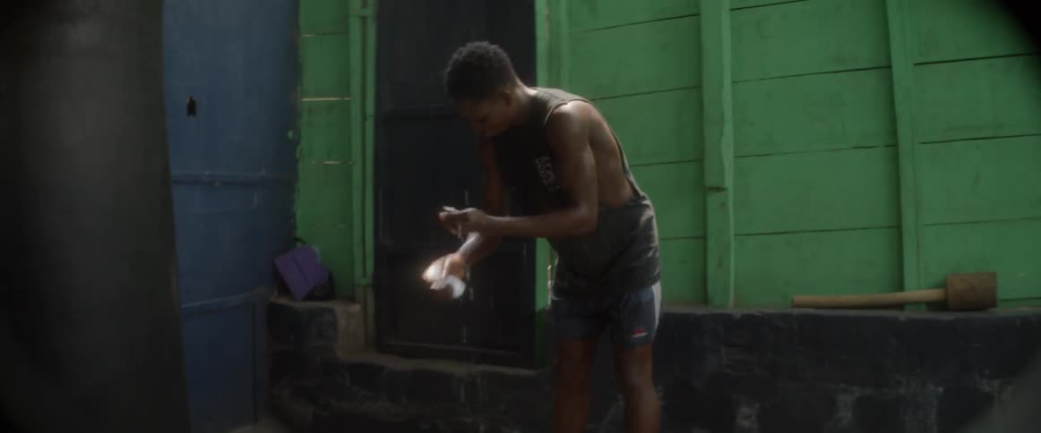 Man squeezes liquid out of a rag outside on a sunny day